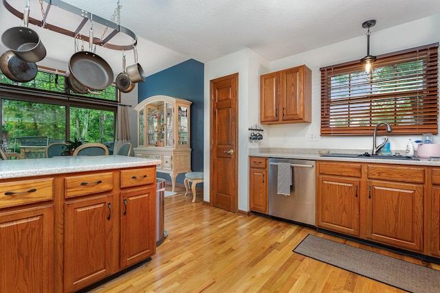 1315 Shelby Cir, Reynoldsburg, OH 43068 - kitchen with stainless steel dishwasher, light countertops, brown cabinets, healthy amount of natural light, and lofted ceiling