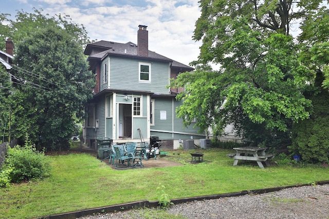368 Alden Ave Unit 368, Columbus, OH 43201 - rear view of property with a chimney, a lawn, and central AC unit