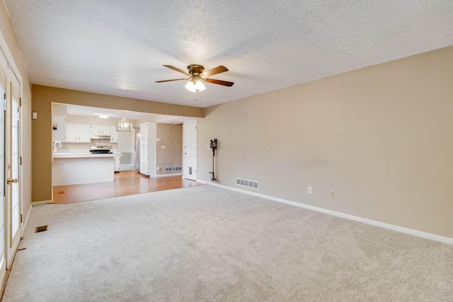 4071 Killary Dr, Dublin, OH 43016 - unfurnished living room featuring light carpet, ceiling fan, baseboards, a textured ceiling, and a sink