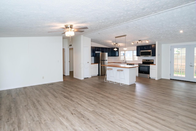 160 Cliff St, Buckeye Lake, OH 43008 - kitchen with stainless steel appliances, open floor plan, a textured ceiling, a center island, and light wood finished floors