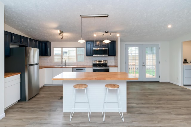 160 Cliff St, Buckeye Lake, OH 43008 - kitchen with stainless steel appliances, backsplash, a textured ceiling, french doors, and washer / dryer