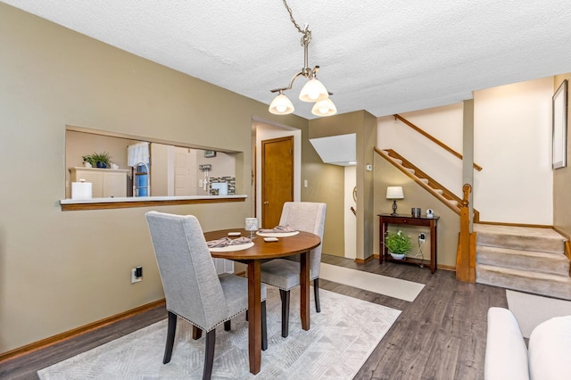 7179 Inverness Ct, Dublin, OH 43016 - dining space featuring stairway, wood finished floors, baseboards, a textured ceiling, and a chandelier