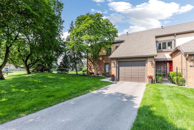 7179 Inverness Ct, Dublin, OH 43016 - view of front of house with asphalt driveway, an attached garage, a shingled roof, a front yard, and brick siding