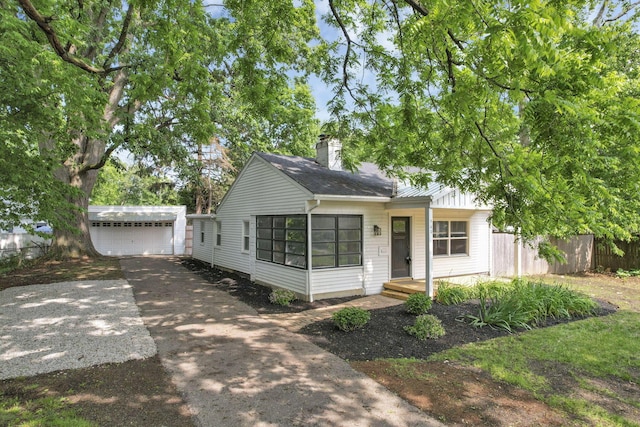 960 College Ave, Columbus, OH 43209 - view of front of house featuring an outdoor structure, driveway, a garage, and a chimney