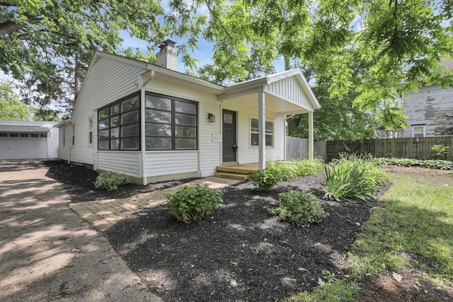960 College Ave, Columbus, OH 43209 - view of front facade with a chimney, an outdoor structure, driveway, and a garage