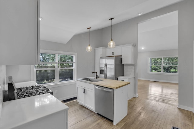 960 College Ave, Columbus, OH 43209 - kitchen with stainless steel appliances, a sink, lofted ceiling, butcher block countertops, and white cabinetry