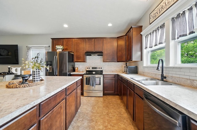 459 Wingate Pl, Mount Sterling, OH 43143 - kitchen featuring appliances with stainless steel finishes, a sink, under cabinet range hood, light countertops, and decorative backsplash