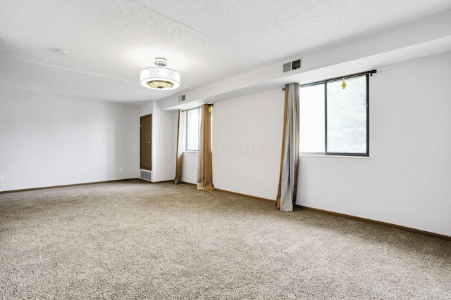 3939 Karl Rd Unit 206, Columbus, OH 43224 - unfurnished room featuring light colored carpet, plenty of natural light, a textured ceiling, and baseboards