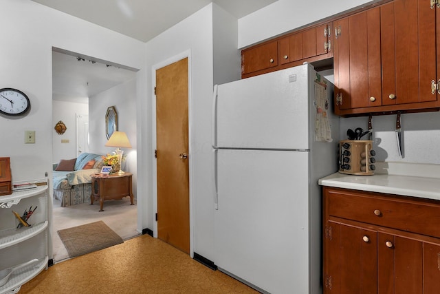 3723 Klibreck Dr, Columbus, OH 43228 - kitchen with freestanding refrigerator, light countertops, and brown cabinetry