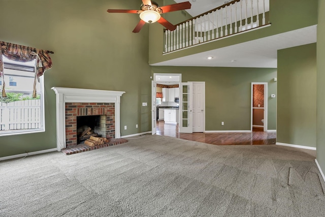 1015 Harborton Dr, Columbus, OH 43228 - unfurnished living room featuring carpet, a towering ceiling, ceiling fan, baseboards, and a brick fireplace