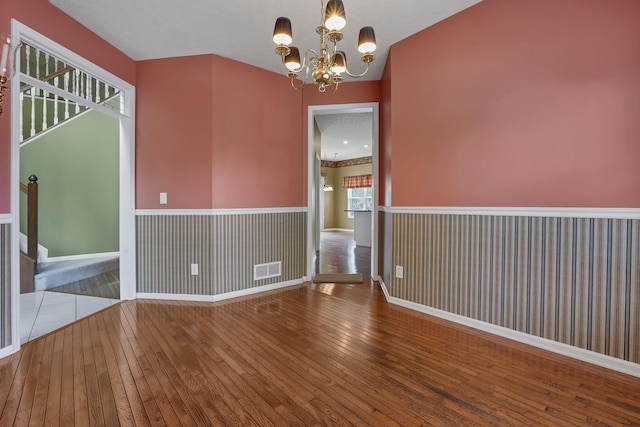 1015 Harborton Dr, Columbus, OH 43228 - unfurnished room with hardwood / wood-style flooring, a chandelier, stairs, and baseboards