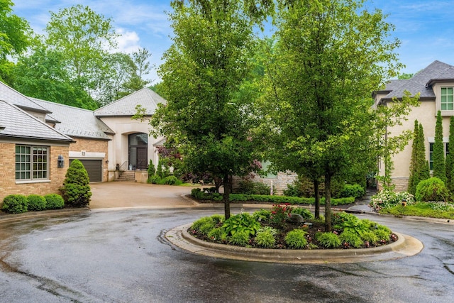 14 Lyonsgate Rd, Bexley, OH 43209 - french country inspired facade featuring driveway, stucco siding, a garage, and brick siding