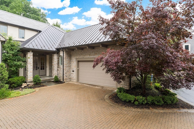 14 Lyonsgate Rd, Bexley, OH 43209 - view of front of home with a standing seam roof, decorative driveway, stone siding, metal roof, and a garage