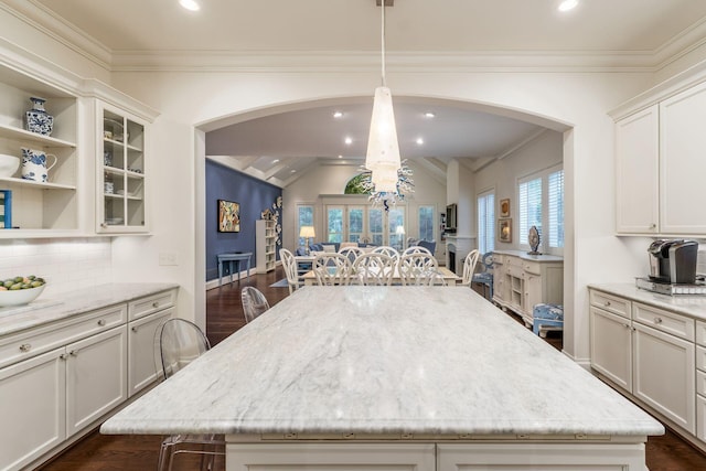 14 Lyonsgate Rd, Bexley, OH 43209 - kitchen with arched walkways, a center island, vaulted ceiling, tasteful backsplash, and light stone counters