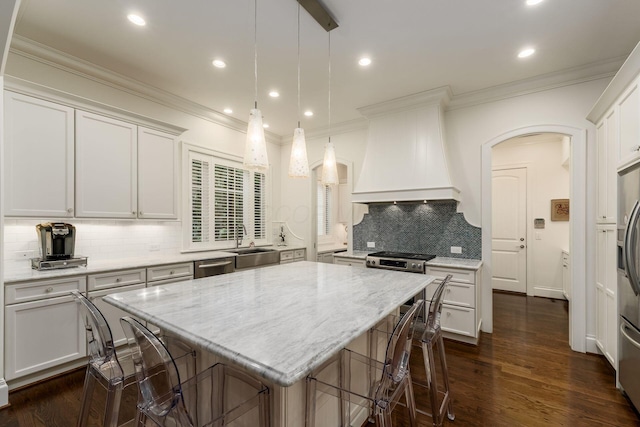 14 Lyonsgate Rd, Bexley, OH 43209 - kitchen featuring premium range hood, arched walkways, stainless steel appliances, a sink, and a breakfast bar