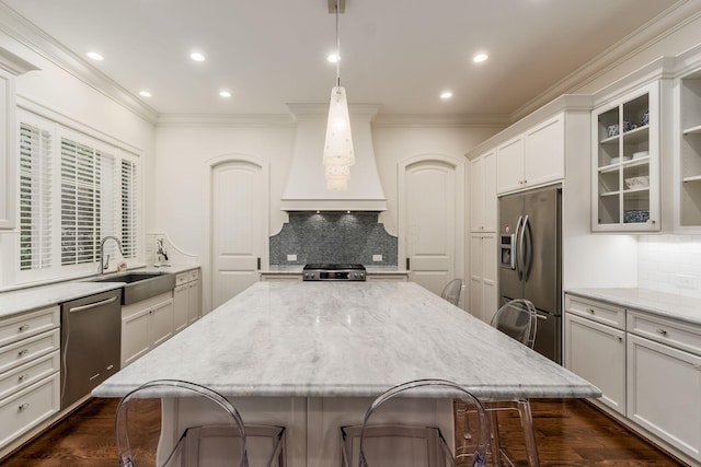 14 Lyonsgate Rd, Bexley, OH 43209 - kitchen with appliances with stainless steel finishes, custom exhaust hood, a sink, ornamental molding, and a breakfast bar