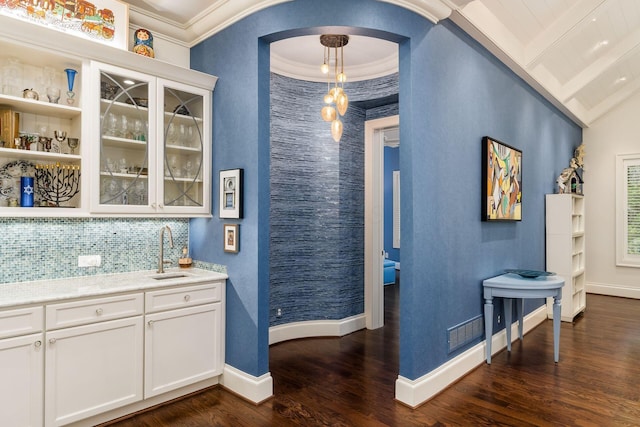 14 Lyonsgate Rd, Bexley, OH 43209 - indoor wet bar featuring arched walkways, dark wood finished floors, backsplash, ornamental molding, and baseboards