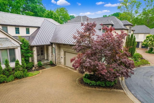 14 Lyonsgate Rd, Bexley, OH 43209 - view of front of home with decorative driveway, a standing seam roof, stone siding, metal roof, and stucco siding