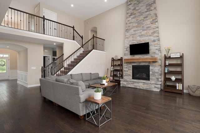 3669 Audubon Ave, Hilliard, OH 43026 - living area featuring arched walkways, a high ceiling, hardwood / wood-style floors, a stone fireplace, and baseboards