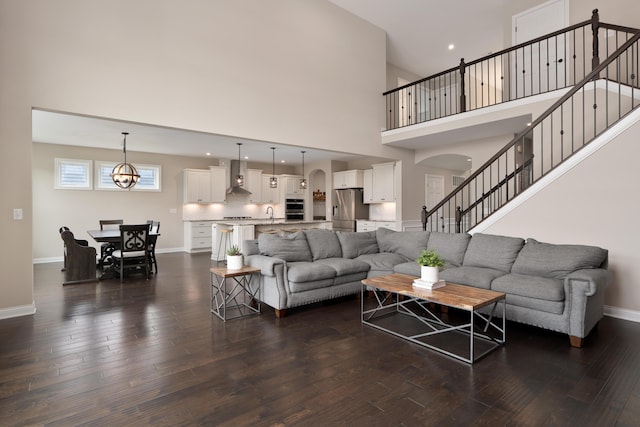3669 Audubon Ave, Hilliard, OH 43026 - living area with arched walkways, dark wood-style flooring, a high ceiling, baseboards, and stairway