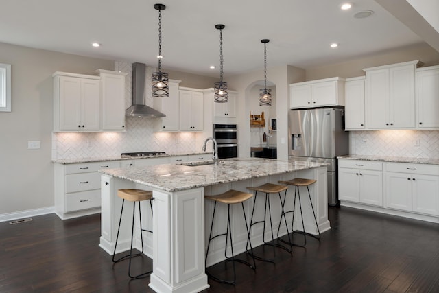 3669 Audubon Ave, Hilliard, OH 43026 - kitchen featuring wall chimney exhaust hood, stainless steel appliances, a sink, backsplash, and a kitchen bar