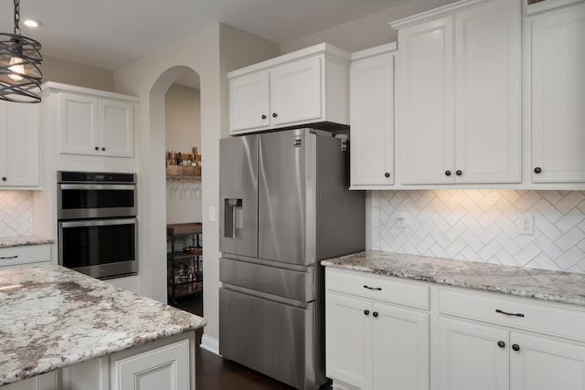 3669 Audubon Ave, Hilliard, OH 43026 - kitchen featuring appliances with stainless steel finishes, arched walkways, backsplash, white cabinetry, and recessed lighting
