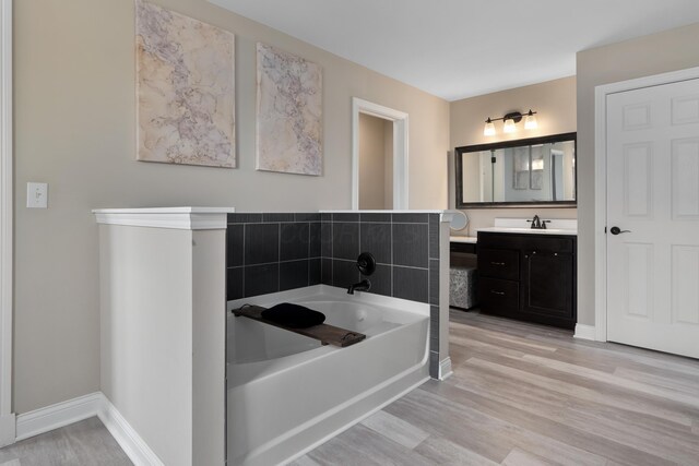 3669 Audubon Ave, Hilliard, OH 43026 - bathroom with a garden tub, vanity, wood finished floors, and baseboards