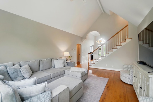 9146 Shawnee Trl, Powell, OH 43065 - living area with high vaulted ceiling, stairway, beam ceiling, wood finished floors, and arched walkways