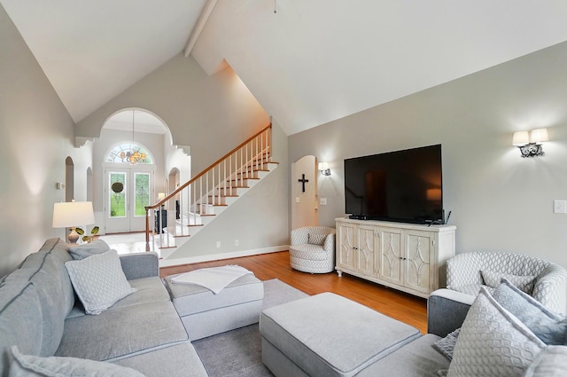 9146 Shawnee Trl, Powell, OH 43065 - living area with high vaulted ceiling, stairway, wood finished floors, arched walkways, and beam ceiling
