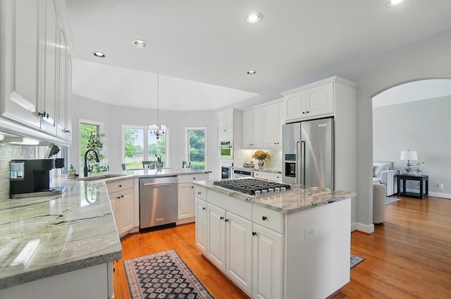 9146 Shawnee Trl, Powell, OH 43065 - kitchen with stainless steel appliances, a sink, arched walkways, decorative backsplash, and white cabinets
