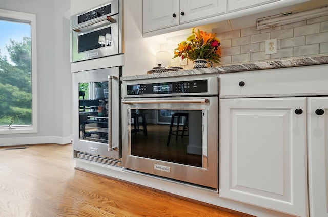 9146 Shawnee Trl, Powell, OH 43065 - kitchen with wine cooler, stainless steel oven, tasteful backsplash, and white cabinetry