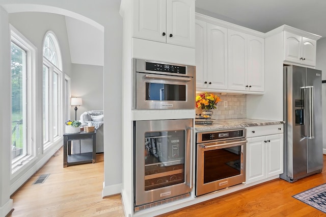 9146 Shawnee Trl, Powell, OH 43065 - kitchen featuring appliances with stainless steel finishes, wine cooler, light wood-style floors, and plenty of natural light