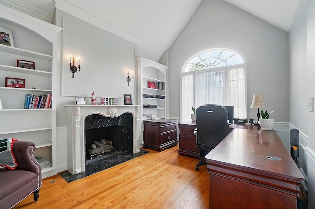 9146 Shawnee Trl, Powell, OH 43065 - office area featuring built in shelves, wood finished floors, a fireplace, and high vaulted ceiling