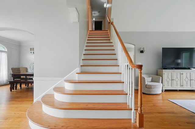 9146 Shawnee Trl, Powell, OH 43065 - stairway with arched walkways, wood finished floors, and ornamental molding
