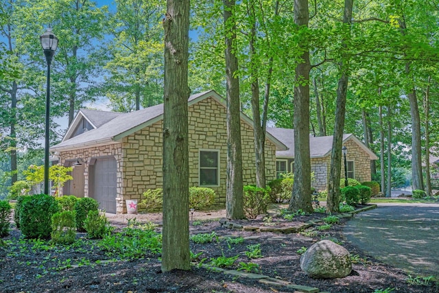 7326 State Route 19 Unit 2, Lots 27-30, Mount Gilead, OH 43338 - view of front of house featuring stone siding, a garage, and a shingled roof