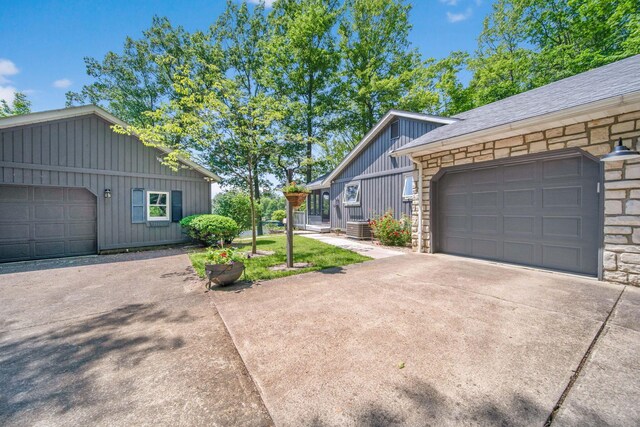 7326 State Route 19 Unit 2, Lots 27-30, Mount Gilead, OH 43338 - view of side of property featuring driveway, a garage, stone siding, and board and batten siding