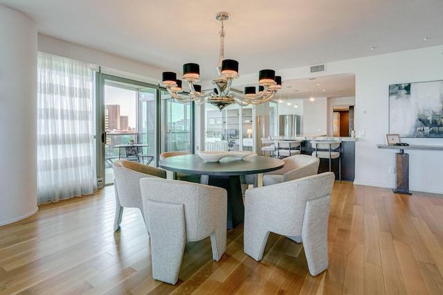 1 Miranova Pl Unit 1225, Columbus, OH 43215 - dining area featuring a chandelier, light wood-type flooring, and baseboards