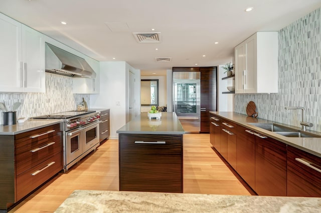 1 Miranova Pl Unit 1225, Columbus, OH 43215 - kitchen featuring premium appliances, range hood, a sink, light wood-style flooring, and a kitchen island