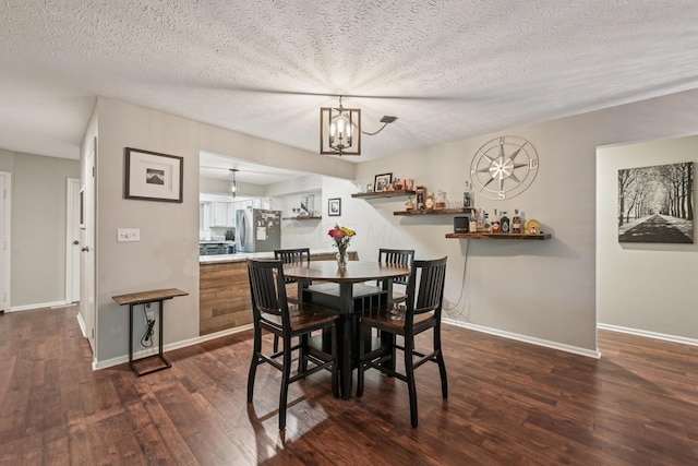 3137 Griggsview Ct Unit 3137, Columbus, OH 43221 - dining room featuring dark wood-style flooring, baseboards, a textured ceiling, and a chandelier