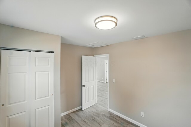 4881 Decker Ave NE, Thornville, OH 43076 - unfurnished bedroom featuring baseboards, light wood-style floors, attic access, and a closet