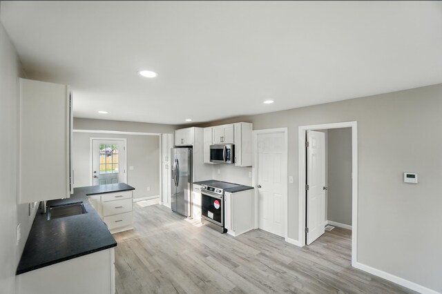 4881 Decker Ave NE, Thornville, OH 43076 - kitchen featuring stainless steel appliances, dark countertops, a sink, white cabinets, and baseboards
