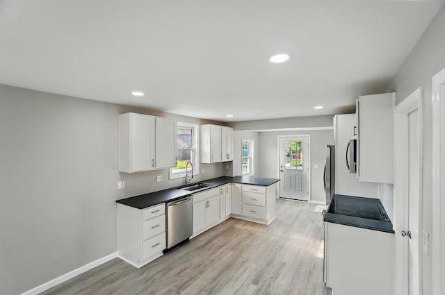 4881 Decker Ave NE, Thornville, OH 43076 - kitchen with stainless steel appliances, a sink, dark countertops, light wood-style flooring, and white cabinetry