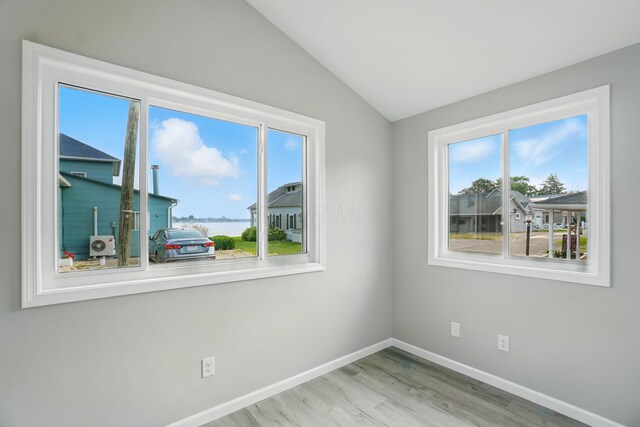 4881 Decker Ave NE, Thornville, OH 43076 - empty room featuring lofted ceiling, plenty of natural light, wood finished floors, baseboards, and a water view