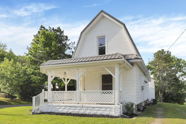 800 S Detroit St, Bellefontaine, OH 43311 - colonial inspired home with a porch, a front lawn, metal roof, a gambrel roof, and central AC unit