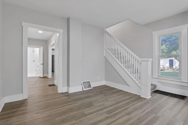 800 S Detroit St, Bellefontaine, OH 43311 - unfurnished living room featuring wood finished floors, stairway, and baseboards