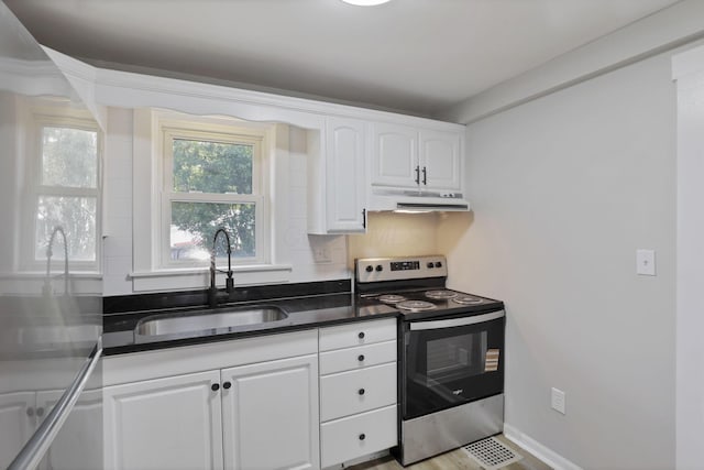 800 S Detroit St, Bellefontaine, OH 43311 - kitchen featuring stainless steel range with electric cooktop, a sink, under cabinet range hood, white cabinetry, and tasteful backsplash