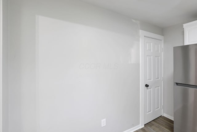 800 S Detroit St, Bellefontaine, OH 43311 - kitchen featuring freestanding refrigerator, white cabinetry, wood finished floors, and baseboards