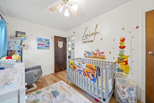 2107 Radnor Ave, Columbus, OH 43224 - bedroom with wood finished floors, a nursery area, baseboards, and a ceiling fan