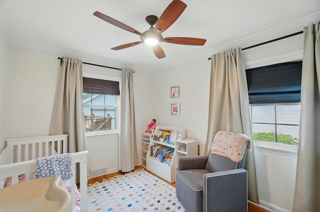 91 Nottingham Rd, Columbus, OH 43214 - bedroom featuring a nursery area, light wood finished floors, ceiling fan, baseboards, and crown molding