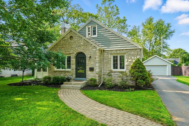 91 Nottingham Rd, Columbus, OH 43214 - view of front facade featuring stone siding, a chimney, a detached garage, and an outdoor structure
